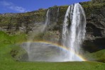 Seljalandsfoss Wasserfall in Sommer mit einem Regenbogen und grnen Gras